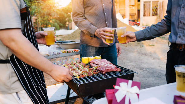 朋友和烧烤聚会时，会举着塑料啤酒杯庆祝新年。图片下载