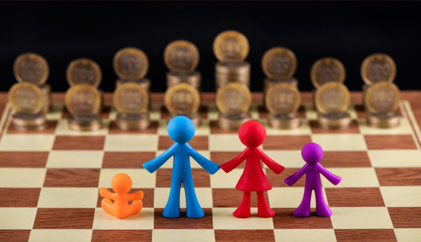 一个象征性的家庭和两个孩子站在由金币制成的棋盘前图片下载