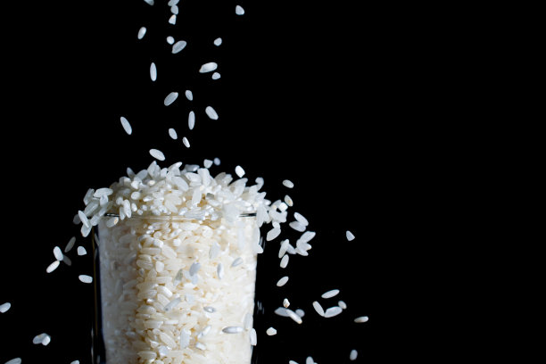 白米倒入玻璃杯中，溅起水花图片下载