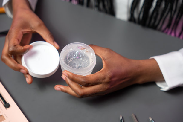 一种凝胶可以在一个深色皮肤的美容博主的手的特写图片下载