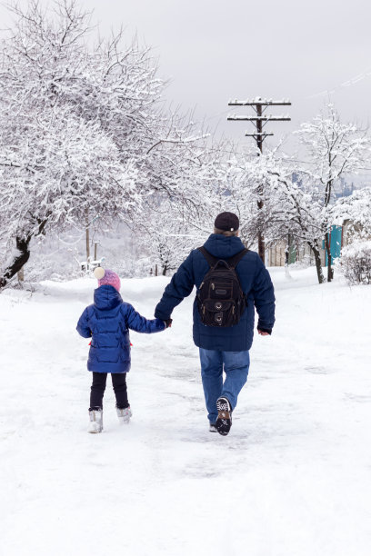 冬天的一天，爸爸和女儿在雪地里散步。冬天的乐趣图片下载