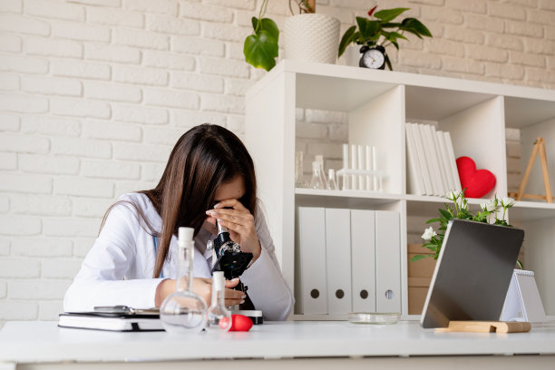年轻的医生或女科学家使用显微镜，研究试管图片下载