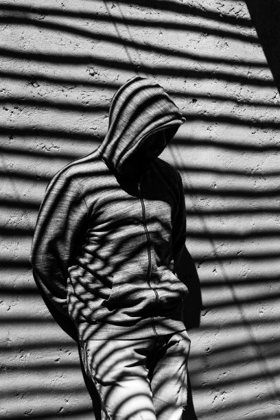 一个穿着黑白衣服的年轻人，手臂放在身体后面。图片下载