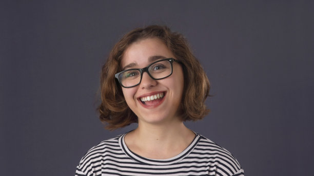 面带微笑的女学生肖像（戴眼镜，赢得学校数学比赛，非常高兴）图片下载