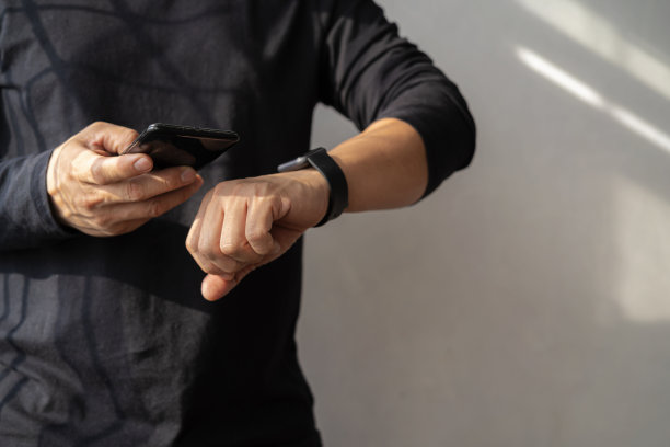 男人在办公室使用智能手表和智能手机图片下载