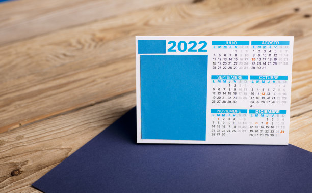 2022年日历(西班牙语月)，在记事本上，木桌与木色背景的桌子图片下载
