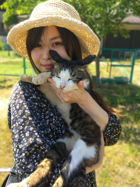 一个日本女人戴着草帽，手里抱着一只猫图片下载