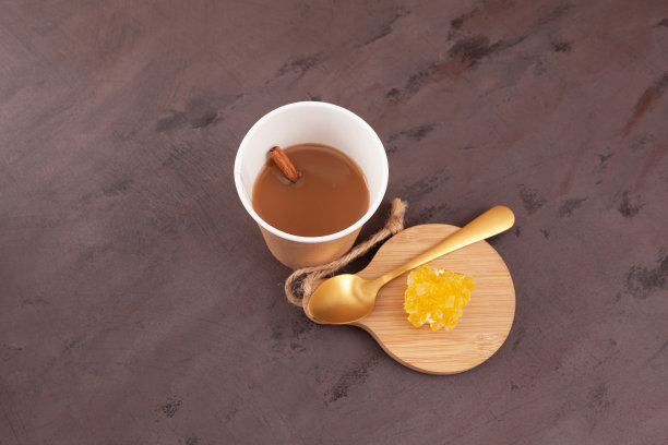 纸玻璃早上孟买茶或切割茶。用牛奶和茶叶，加上姜和香料。茶水和冰糖放在棕色的桌子上图片下载