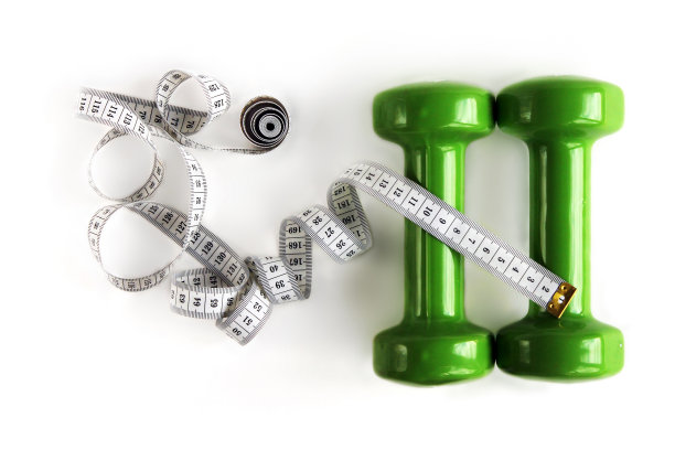 两个绿色的哑铃和扭曲的卷尺孤立在白色，俯视图图片下载
