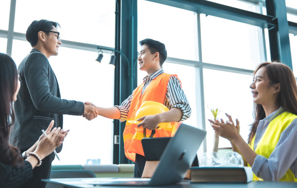 戴安全帽的工业工程师。在重工业制造工厂工作。工业工人在工厂室内。一个在工业工厂工作的老人。在工厂开会、握手。图片下载