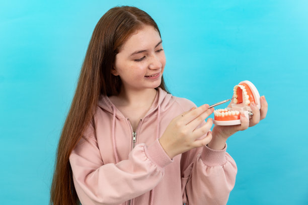 牙齿美丽的微笑年轻女子与牙套高兴的情绪与白色的牙齿增加自信健康的蓝色背景孤立，快乐有趣的少女刷牙，健康的概念，图片下载