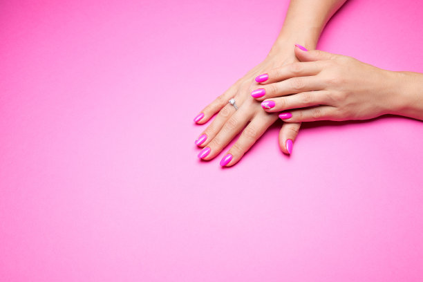 时尚的粉红色指甲在粉红色的背景图片下载