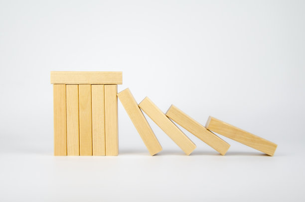 密密麻麻的木块可以阻止掉落的木块。团队合作的概念。多米诺骨牌效应图片下载
