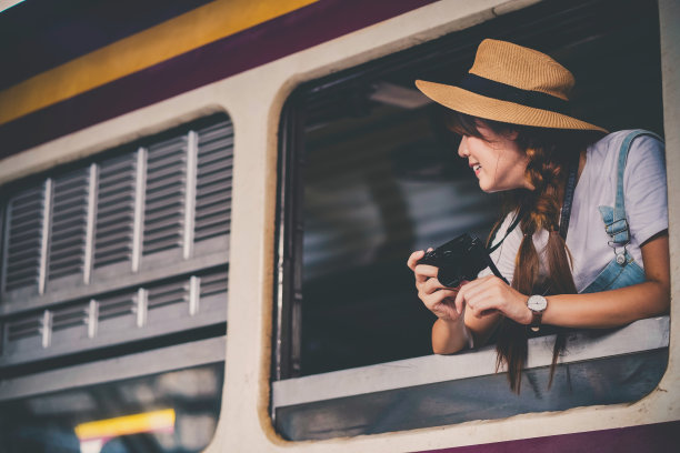 亚洲年轻女孩拍照，快乐的旅客在火车上。图片下载