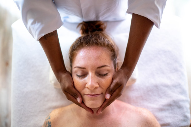 中年妇女在水疗中心接受面部按摩图片下载