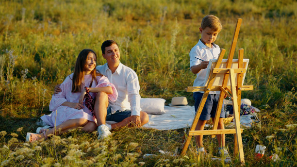 一个小艺术家在户外家庭野餐时画画图片下载