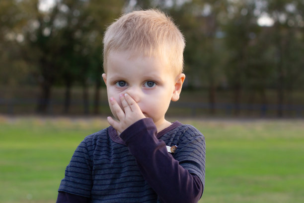 (特写)小男孩感冒了，流鼻涕。(特写)小男孩的鼻子里流着粘液。孩子流鼻涕，流鼻涕，感染病毒，在外面生病图片下载