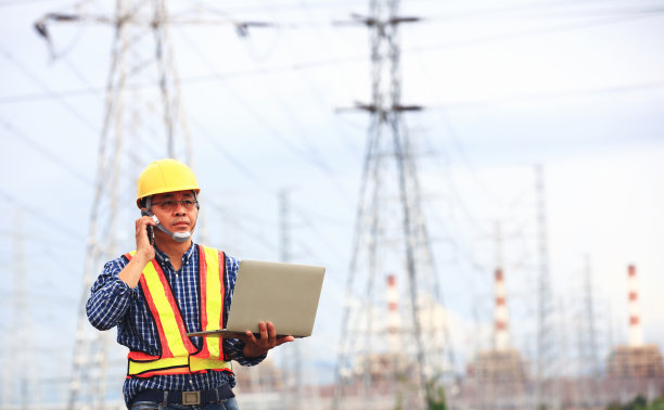 高级工程师操作笔记本电脑和使用电话会议工作，工程师使用手机联系工作图片下载