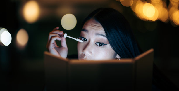 一个年轻的亚洲女人在街上补妆图片下载