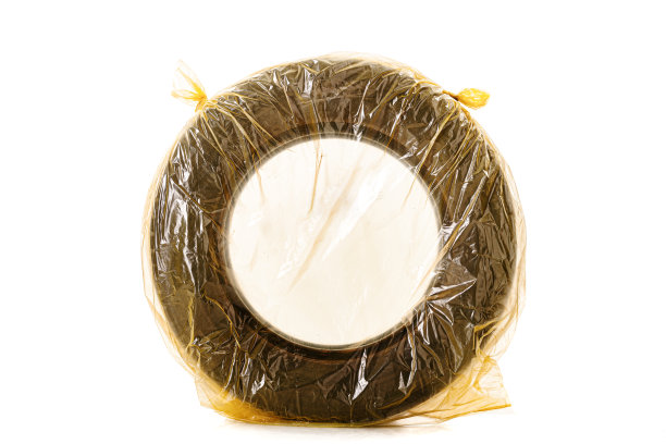 汽车轮胎装在黄色袋子里存放。一个冬季轮胎孤立在白色背景..图片下载