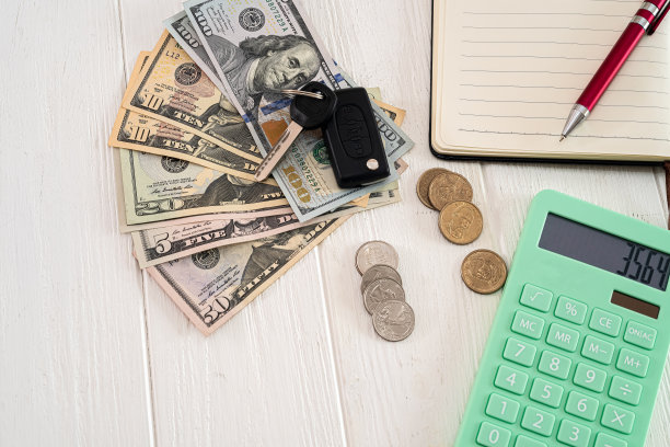 木桌上放着美元硬币的车钥匙、钢笔和笔记本图片下载