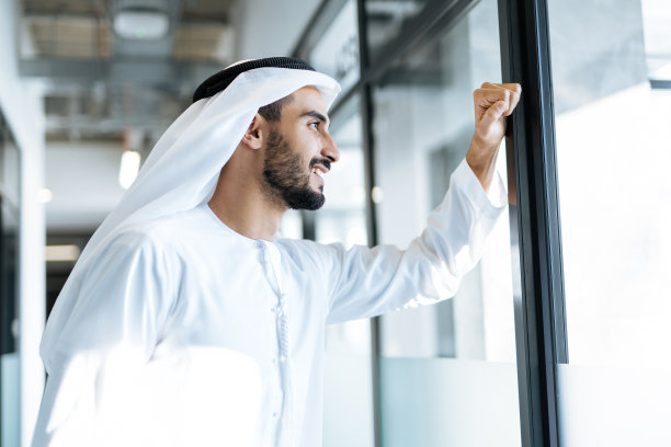 穿着传统服装在迪拜办公室工作的英俊男人图片下载