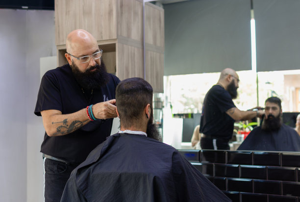 留着胡子的男理发师在他例行的工作中图片下载