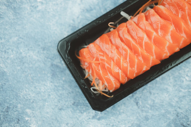 新鲜生三文鱼生鱼片。在线订餐和外卖的概念。图片下载