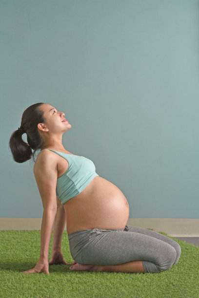 健康的孕妇坐在草地上想着好事图片下载