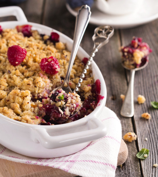 李子和覆盆子屑在古老的木质背景上。乡村风格。有选择性的重点。图片下载