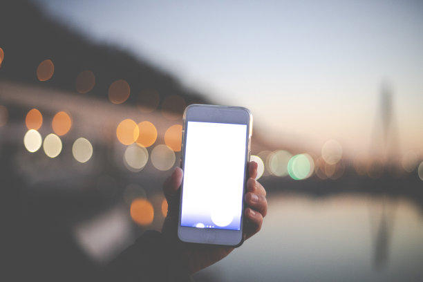 女人手持智能手机伴着夕阳图片下载