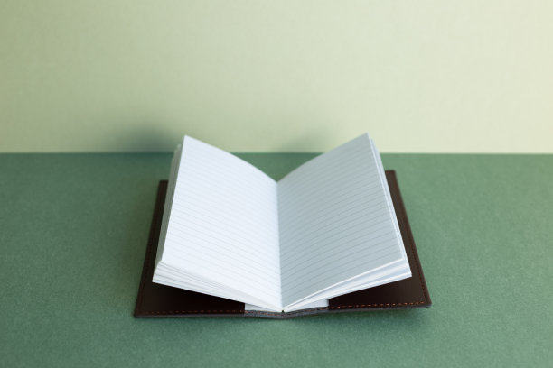 打开笔记本在绿色的书桌背景图片下载