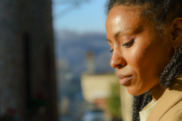 年轻的非裔美国妇女在白色冬装摆姿势在老城区图片下载