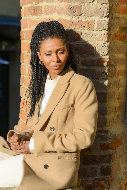 年轻的非裔美国妇女在白色冬装摆姿势在老城区图片下载