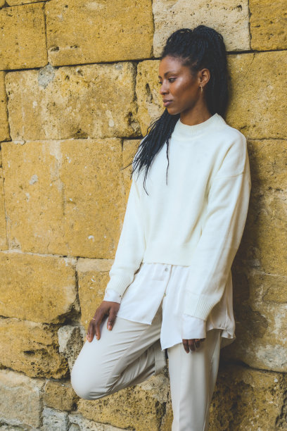 年轻的非裔美国妇女在白色冬装摆姿势在老城区图片下载