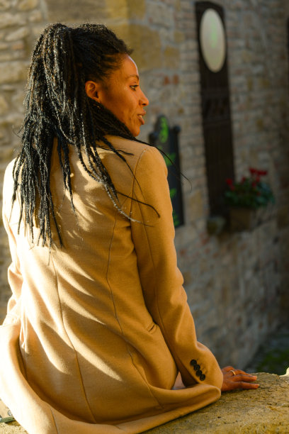 年轻的非裔美国妇女在白色冬装摆姿势在老城区图片下载