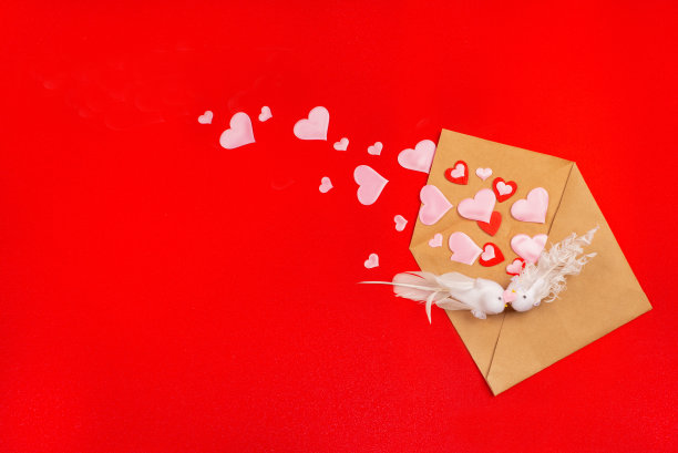 节日背景与接吻的鸟在爱，坐在一个信封与飞出的心在红色的背景。情人节贺卡或婚礼请柬图片下载
