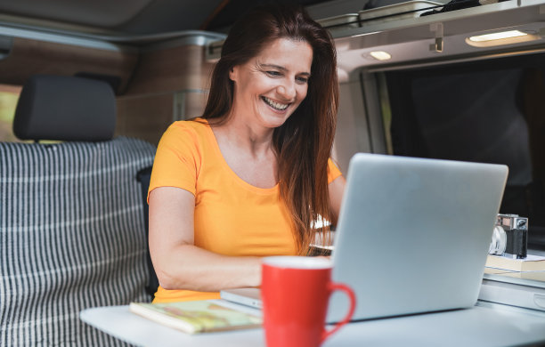 白人妇女工作在迷你面包车露营与电脑笔记本电脑图片下载