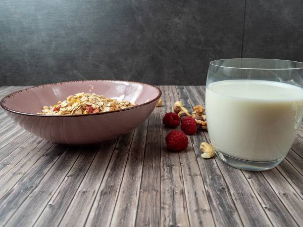 杯子里的牛奶什锦麦片，木桌上的一杯牛奶。木制背景的什锦早餐图片下载