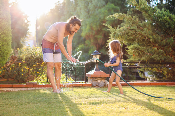 一个幸福的家庭通过洒水喷头图片下载