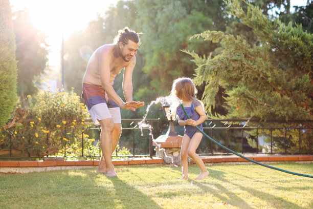 一个幸福的家庭通过洒水喷头图片下载