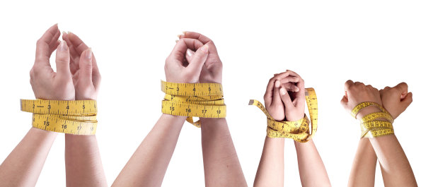 节食概念的手绑在卷尺变化的白色背景上图片下载