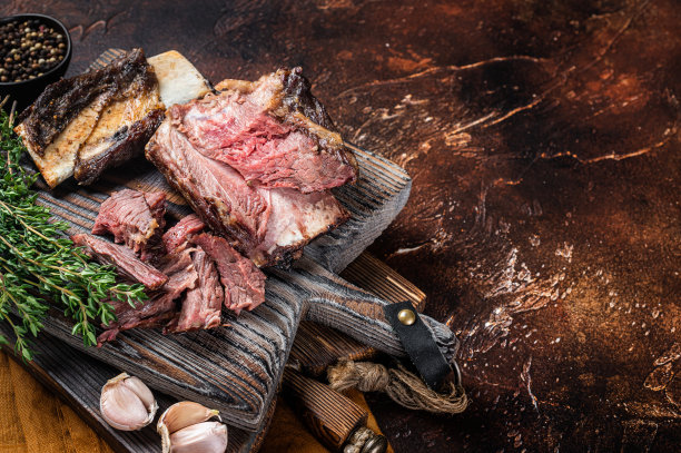 百里香木切菜板炖小牛肉排骨。黑暗的背景。前视图。本空间图片下载