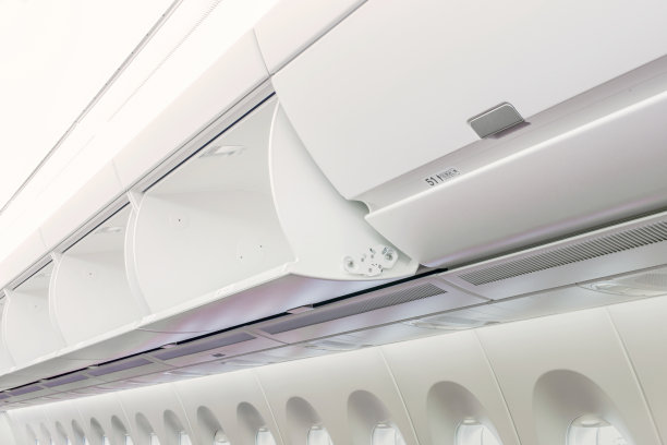 商务飞机上放在头顶行李架上的随身行李。图片下载