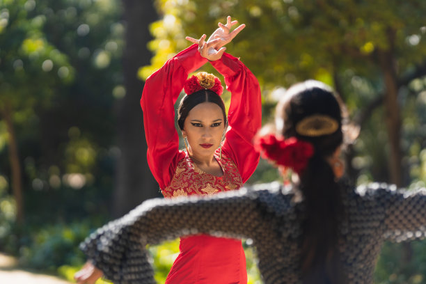 两个穿着弗拉门戈舞的女人在公园里面对面地跳舞图片下载