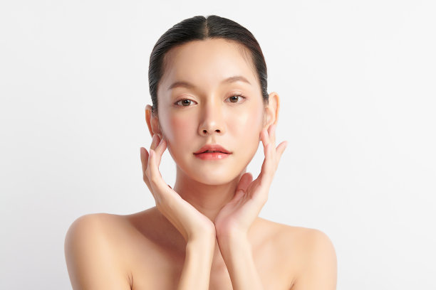 美丽年轻的亚洲女性干净清新的皮肤在白色背景，面部护理，面部护理，美容，美容和水疗，亚洲女性肖像。素材图片