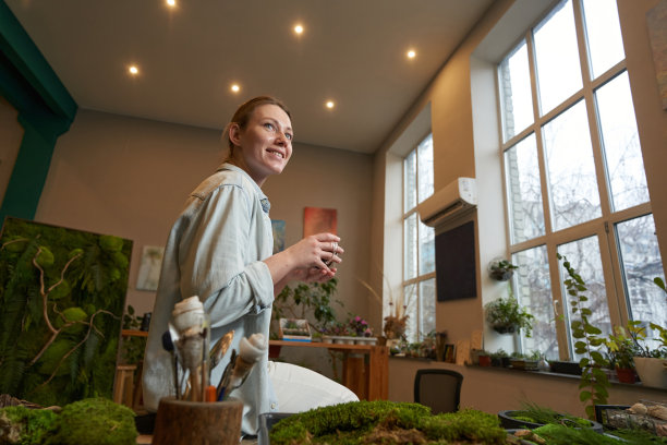 微笑的女人拿着一杯饮料站在演播室里图片下载