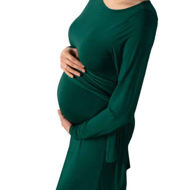 一名身穿绿色连衣裙的孕妇将手放在她腹部孤立的白色上图片下载