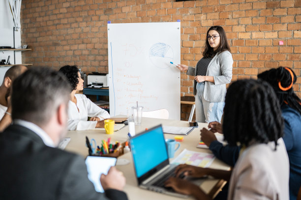年轻女性在共同办公的办公室里为同事们做商务演讲图片下载