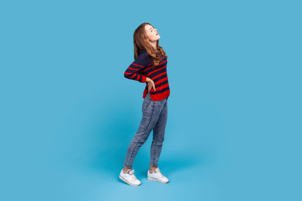 背部强烈疼痛的妇女，用手触摸和按压背部，闭上眼睛以减轻疼痛。图片下载